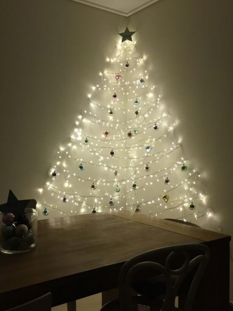 Christmas Tree Ideas: How to Choose Decor in 2021 206 05 a wall mounted Christmas tree of lights and ornaments created between two walls to make it dimensional